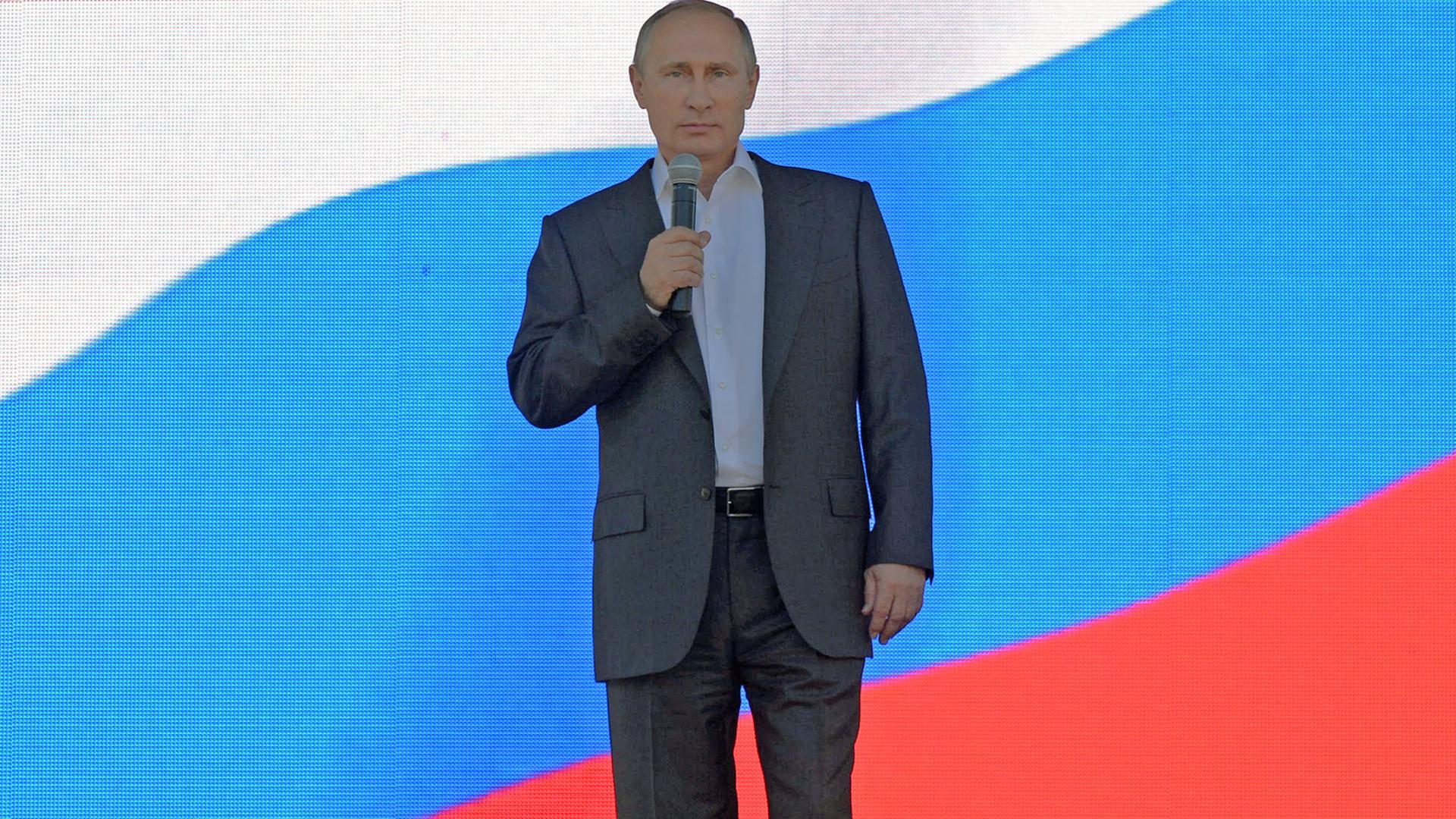 Präsident Wladimir Putin vor einer russischen Flagge. Präsident Wladimir Putin vor einer russischen Flagge.