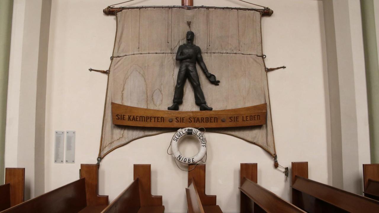 Neben den Kirchenbänken der Garnisonkirche Wilhelmshafen prangen die Wappen bedeutender Schiffe vergangener Zeiten inklusive der U-Boot-Flott

