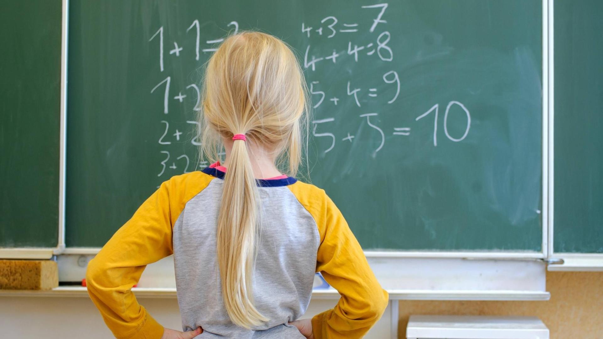 Ein Schulkind steht nachdenklich vor Gleichungen an einer Schultafel in Dresden Ein Schulkind steht nachdenklich vor Gleichungen an einer Schultafel in Dresden