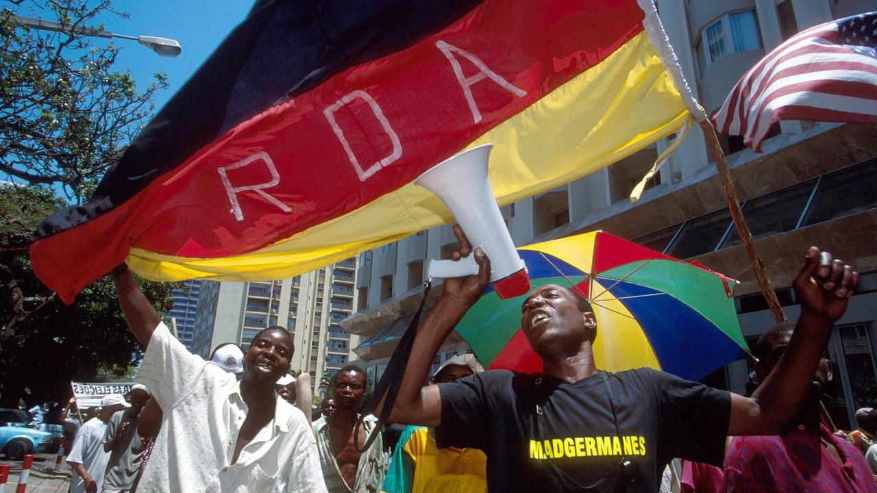Bildnummer: 51407506 Datum: 20.11.2003 Copyright: imago/Friedrich Stark
Ehemalige mosambikanische DDR-Gastarbeiter (Madgermanes) protestieren in der Hauptstadt Maputo für die Auszahlung ihrer in der Deutschen Demokratischen Republik erworbenen Sozialabgaben, Personen , Objekte; 2003, Maputo, Demonstrationen, Kundgebung, Kundgebungen, Demonstrant, Demonstranten, Protest, Proteste, Protestaktion, Protestaktionen, Fahne, Fahnen, Flagge, Flaggen, deutsche, Schriftzug, RDA, Madgermanes, Lautsprecher, Land, Leute , Mann, Männer, Einheimischer, Einheimische; , quer, Kbdig, Gruppenbild, Mosambique, , Politik, Mosambikaner Bildnummer: 51407506 Datum: 20.11.2003 Copyright: imago/Friedrich Stark
Ehemalige mosambikanische DDR-Gastarbeiter (Madgermanes) protestieren in der Hauptstadt Maputo für die Auszahlung ihrer in der Deutschen Demokratischen Republik erworbenen Sozialabgaben, Personen , Objekte; 2003, Maputo, Demonstrationen, Kundgebung, Kundgebungen, Demonstrant, Demonstranten, Protest, Proteste, Protestaktion, Protestaktionen, Fahne, Fahnen, Flagge, Flaggen, deutsche, Schriftzug, RDA, Madgermanes, Lautsprecher, Land, Leute , Mann, Männer, Einheimischer, Einheimische; , quer, Kbdig, Gruppenbild, Mosambique, , Politik, Mosambikaner