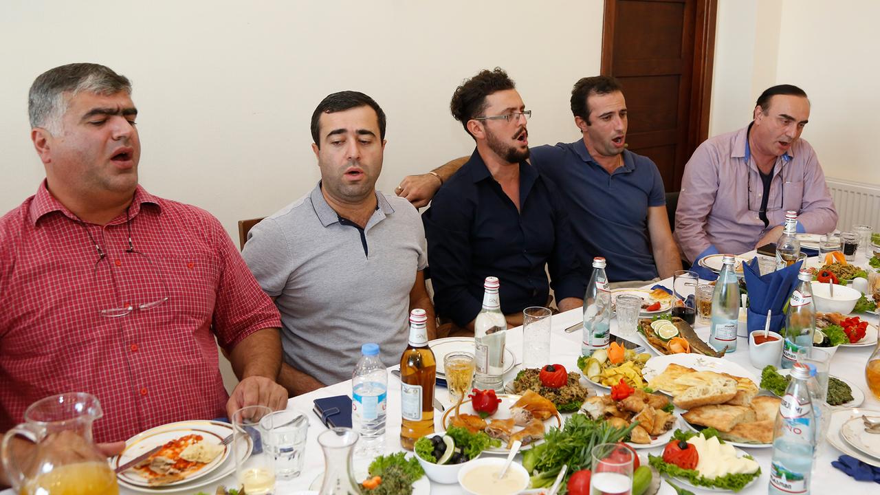 Der Männerchor Rustavi-Ensemble improvisiert an einer festlich gedeckten Tafel. Der Männerchor Rustavi-Ensemble improvisiert an einer festlich gedeckten Tafel.