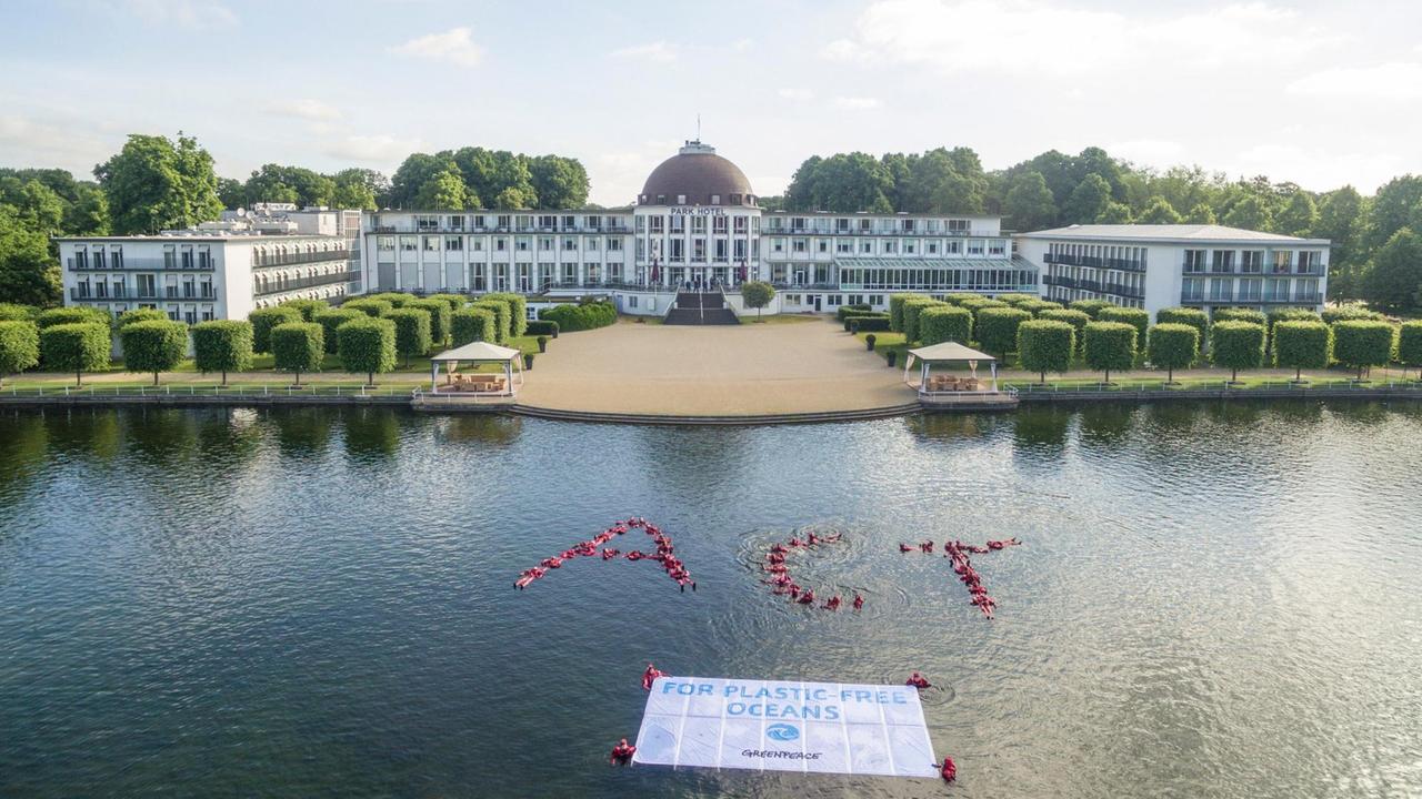 Greenpeace-Aktivisten schwimmen in Bremen vor dem Parkhotel im Hollersee und zeigen dabei ein Transparent mit dem Schriftzug "For Plastic Free Oceans" (Für plastikfreie Ozeane) Greenpeace-Aktivisten schwimmen in Bremen vor dem Parkhotel im Hollersee und zeigen dabei ein Transparent mit dem Schriftzug "For Plastic Free Oceans" (Für plastikfreie Ozeane)