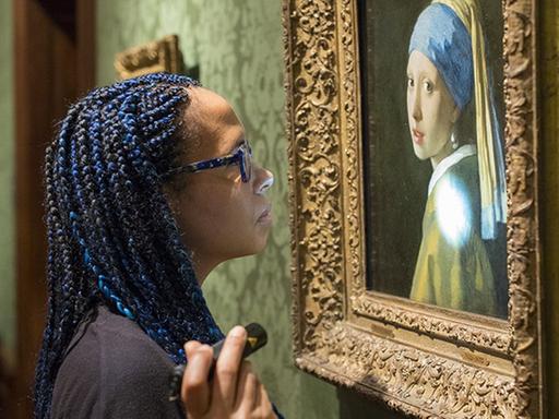 Die Forschungsleiterin Abbie Vandivere untersucht das Gemälde Mädchen mit Perlenohrring.