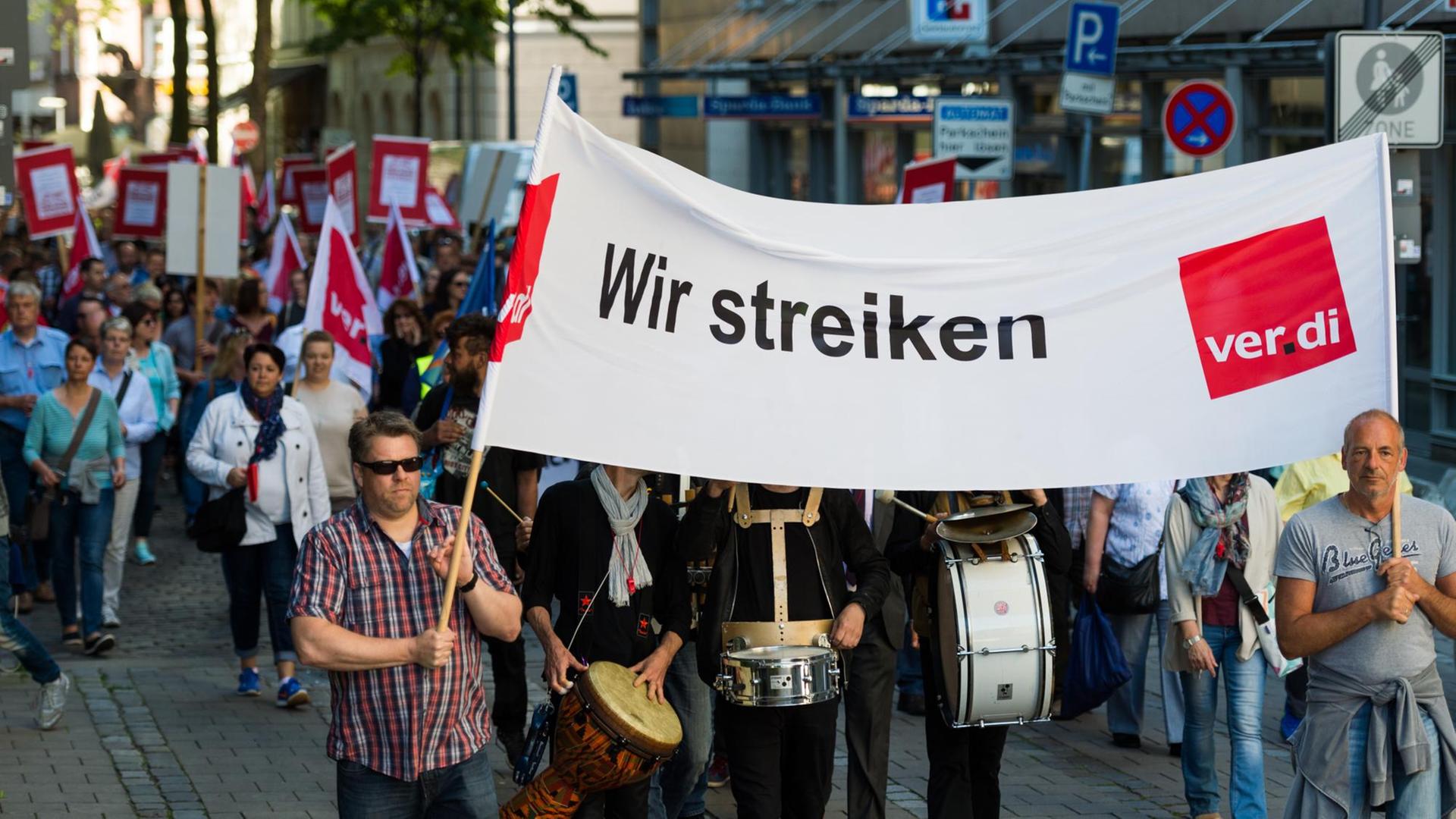 Zwei Demonstranten tragen am 02.06.2017 in Hamburg ein Transparent mit der Aufschrift "Wir streiken". Die Gewerkschaft Verdi erhöht vor der dritten Verhandlungsrunde für die Versicherungsbeschäftigten am 02.06.2017 den Druck auf die Arbeitgeberseite und erwartet ein deutliches Entgegenkommen. Zwei Demonstranten tragen am 02.06.2017 in Hamburg ein Transparent mit der Aufschrift "Wir streiken". Die Gewerkschaft Verdi erhöht vor der dritten Verhandlungsrunde für die Versicherungsbeschäftigten am 02.06.2017 den Druck auf die Arbeitgeberseite und erwartet ein deutliches Entgegenkommen.
