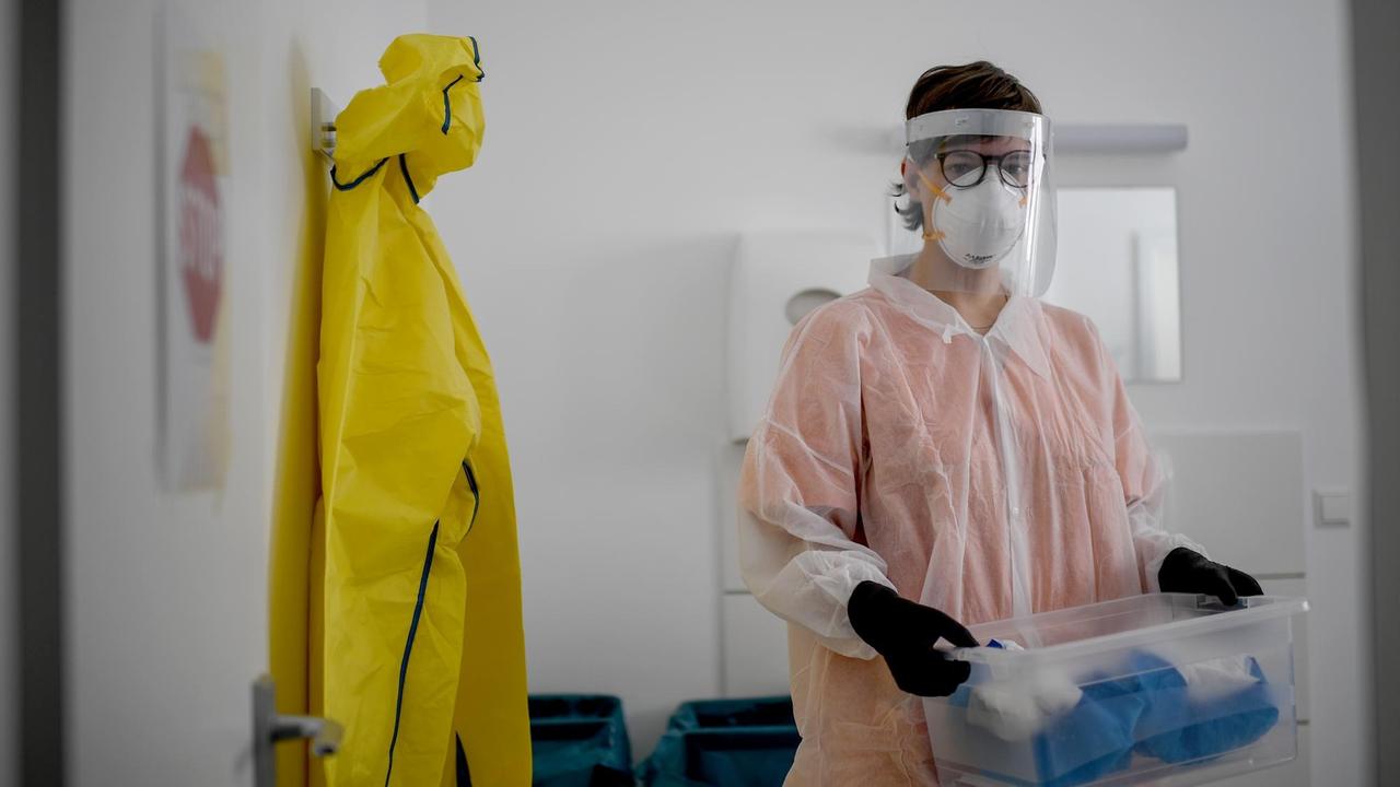 Eine Mitarbeiterin steht in der Schleuse zur ersten Quarantäne-Station für Obdachlose. In der Einrichtung können bis zu 16 obdachlose Menschen unterkommen, die am Coronavirus erkrankt sind und in häuslicher Quarantäne bleiben müssten. Eine Mitarbeiterin steht in der Schleuse zur ersten Quarantäne-Station für Obdachlose. In der Einrichtung können bis zu 16 obdachlose Menschen unterkommen, die am Coronavirus erkrankt sind und in häuslicher Quarantäne bleiben müssten.