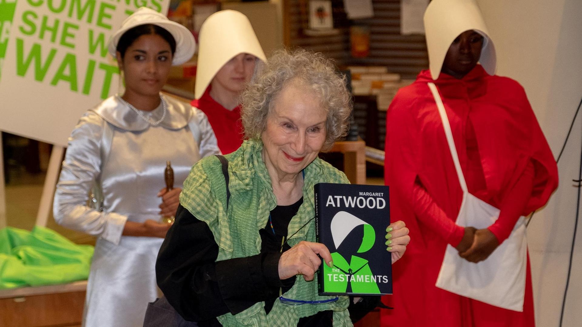 Margaret Atwood posiert mit ihrem neuen Roman "Die Zeuginnen" und als Figuren aus dem Roman verkleideten Schauspielerinnen bei einer Lesung in einem Londoner Buchladen. Margaret Atwood posiert mit ihrem neuen Roman "Die Zeuginnen" und als Figuren aus dem Roman verkleideten Schauspielerinnen bei einer Lesung in einem Londoner Buchladen.
