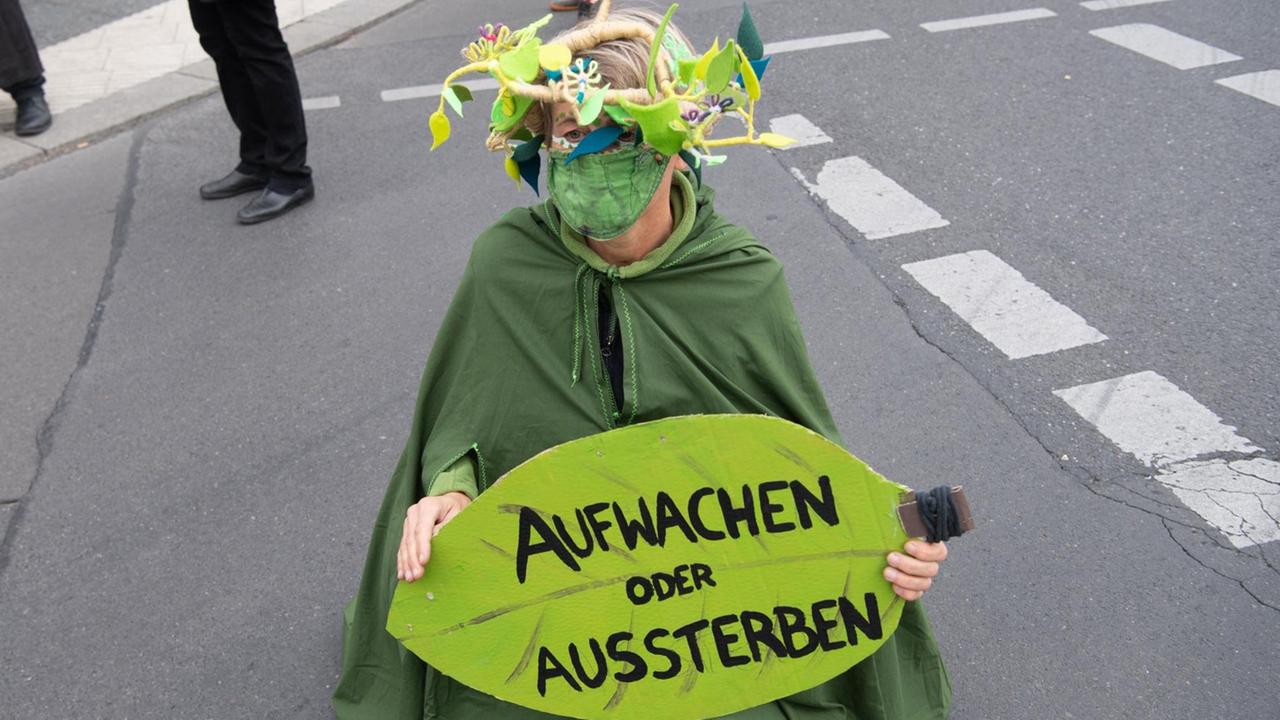 Eine Umweltaktivistin hält während einer Demonstration unter dem Motto «Trauerzug der toten Bäume» von Extinction Rebellion (XR) unweit des Bundeslandwirtschaftsministeriums ein Schild mit der Aufschrift «Aufwachen statt Aussterben». Für diese Woche hat Extinction Rebellion Protestaktionen gegen Umweltzerstörung und Klimawandel angekündigt. Eine Umweltaktivistin hält während einer Demonstration unter dem Motto «Trauerzug der toten Bäume» von Extinction Rebellion (XR) unweit des Bundeslandwirtschaftsministeriums ein Schild mit der Aufschrift «Aufwachen statt Aussterben». Für diese Woche hat Extinction Rebellion Protestaktionen gegen Umweltzerstörung und Klimawandel angekündigt.