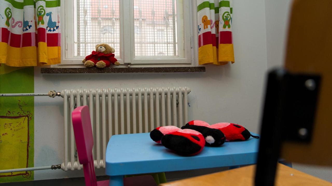 Plüschfiguren liegen in einem Spielzimmer mit vergitterten Fenstern herum. Plüschfiguren liegen in einem Spielzimmer mit vergitterten Fenstern herum.