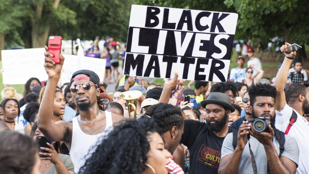 Mann hält bei Demonstration ein Schild hoch: "Black Lives Matter" Mann hält bei Demonstration ein Schild hoch: "Black Lives Matter"