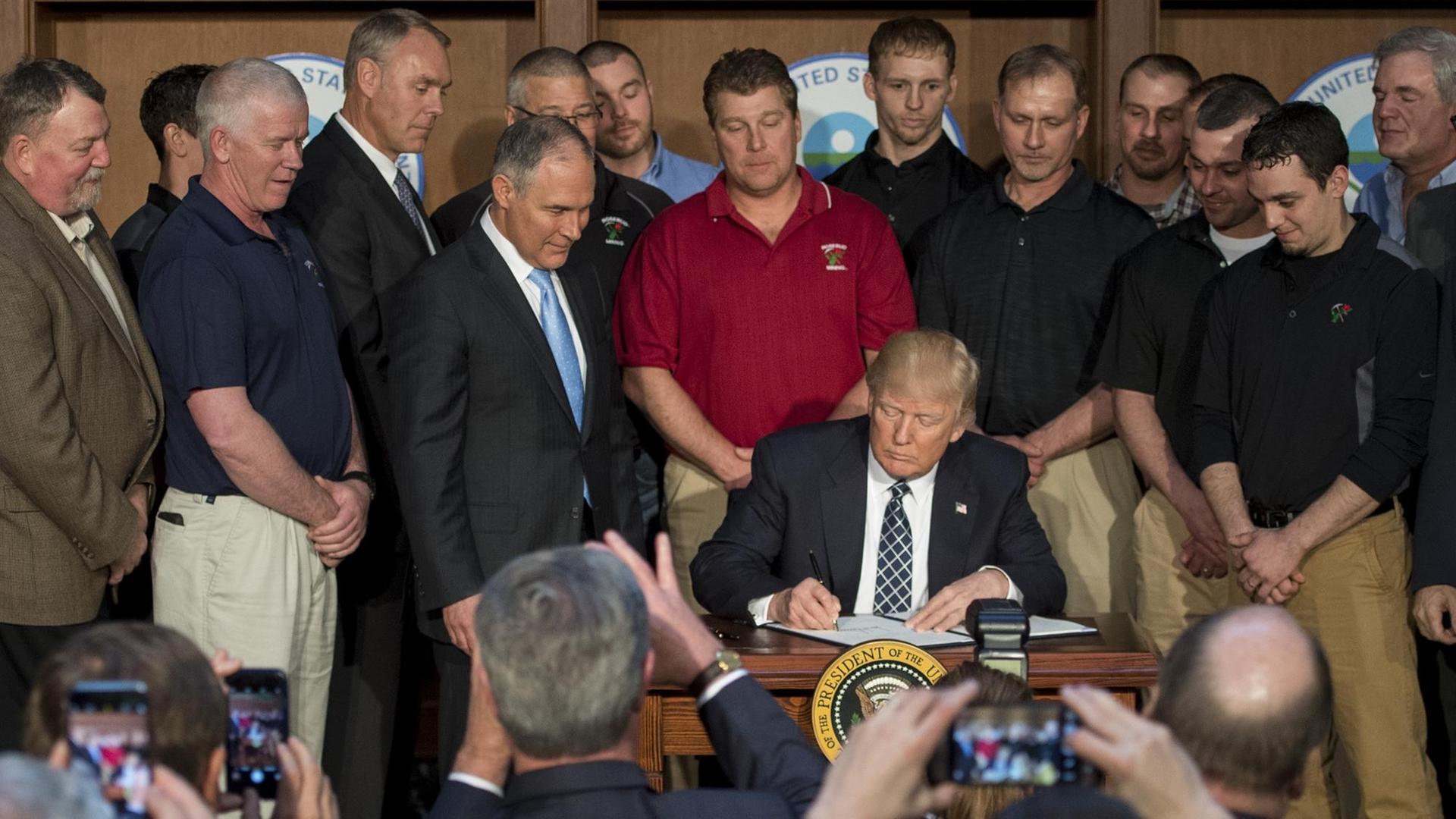 US-Präsident Donald Trump unterzeichnet ein Dekret, das die Klimaschutz-Pläne seines Vorgängers Barack Obama aufweicht. US-Präsident Donald Trump unterzeichnet ein Dekret, das die Klimaschutz-Pläne seines Vorgängers Barack Obama aufweicht.