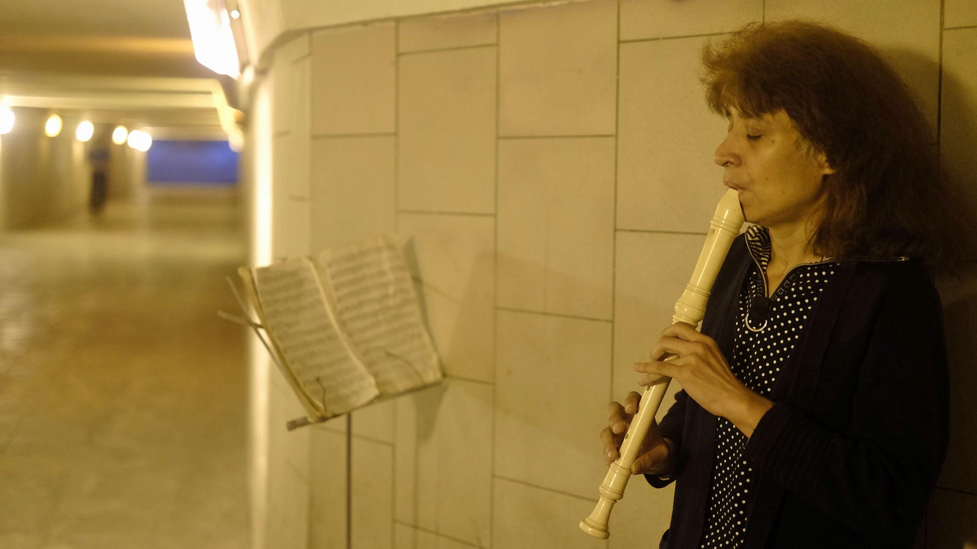 Die Straßenmusikerin Inna spielt in einer Unterführung in Moskau Flöte. Die Straßenmusikerin Inna spielt in einer Unterführung in Moskau Flöte.