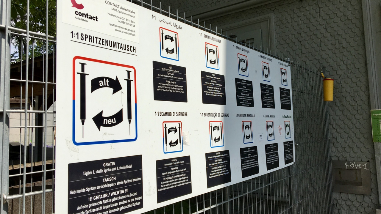 Ein Schild an einem Zaun gibt Aufschluss darüber, dass hier Heroinspritzen umgetauscht werden können. Ein Schild an einem Zaun gibt Aufschluss darüber, dass hier Heroinspritzen umgetauscht werden können.