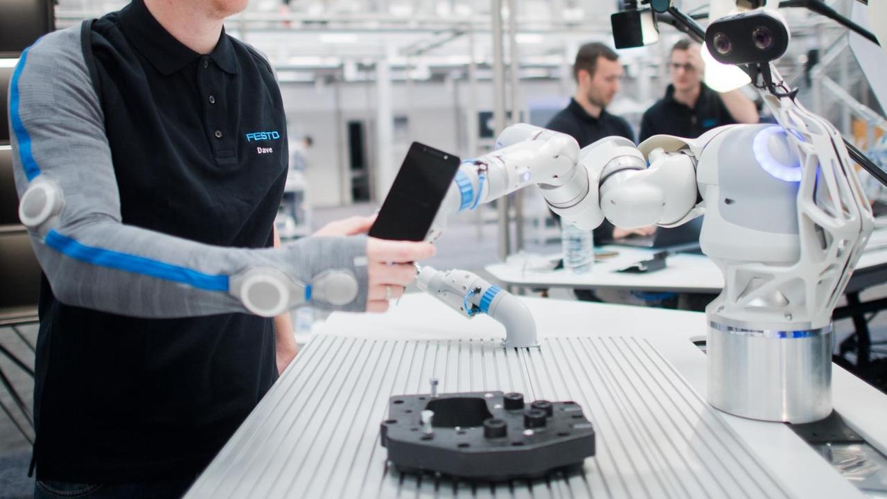 22.04.2018, Niedersachsen, Hannover: Entwickler Christian Trapp interagiert bei der Hannover Messe am Stand von Festo mit einem Roboterarm. Festo zeigt mit dem BionicWorkplace einen Arbeitsplatz für die Mensch-Roboter-Kollaboration. 22.04.2018, Niedersachsen, Hannover: Entwickler Christian Trapp interagiert bei der Hannover Messe am Stand von Festo mit einem Roboterarm. Festo zeigt mit dem BionicWorkplace einen Arbeitsplatz für die Mensch-Roboter-Kollaboration.