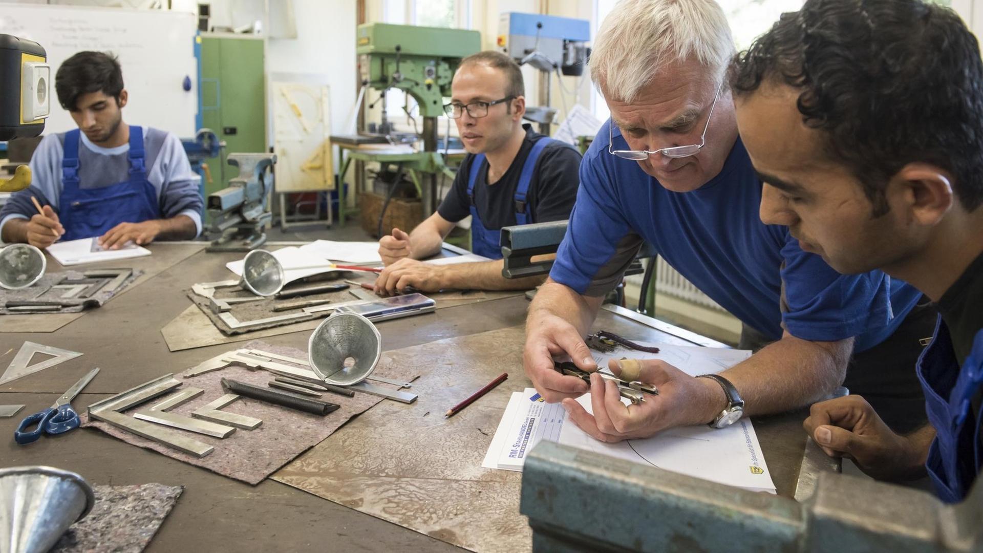 Der Ausbilder für Metallbearbeitung, Waldemar Balakin (2nd r), unterhält sich am am 25.08.2016 im Bildungszentrum vom Internationalen Bund (IB) in Jena (Thüringen) mit jungen Flüchtlingen aus Afghanistan. Der Ausbilder für Metallbearbeitung, Waldemar Balakin (2nd r), unterhält sich am am 25.08.2016 im Bildungszentrum vom Internationalen Bund (IB) in Jena (Thüringen) mit jungen Flüchtlingen aus Afghanistan.