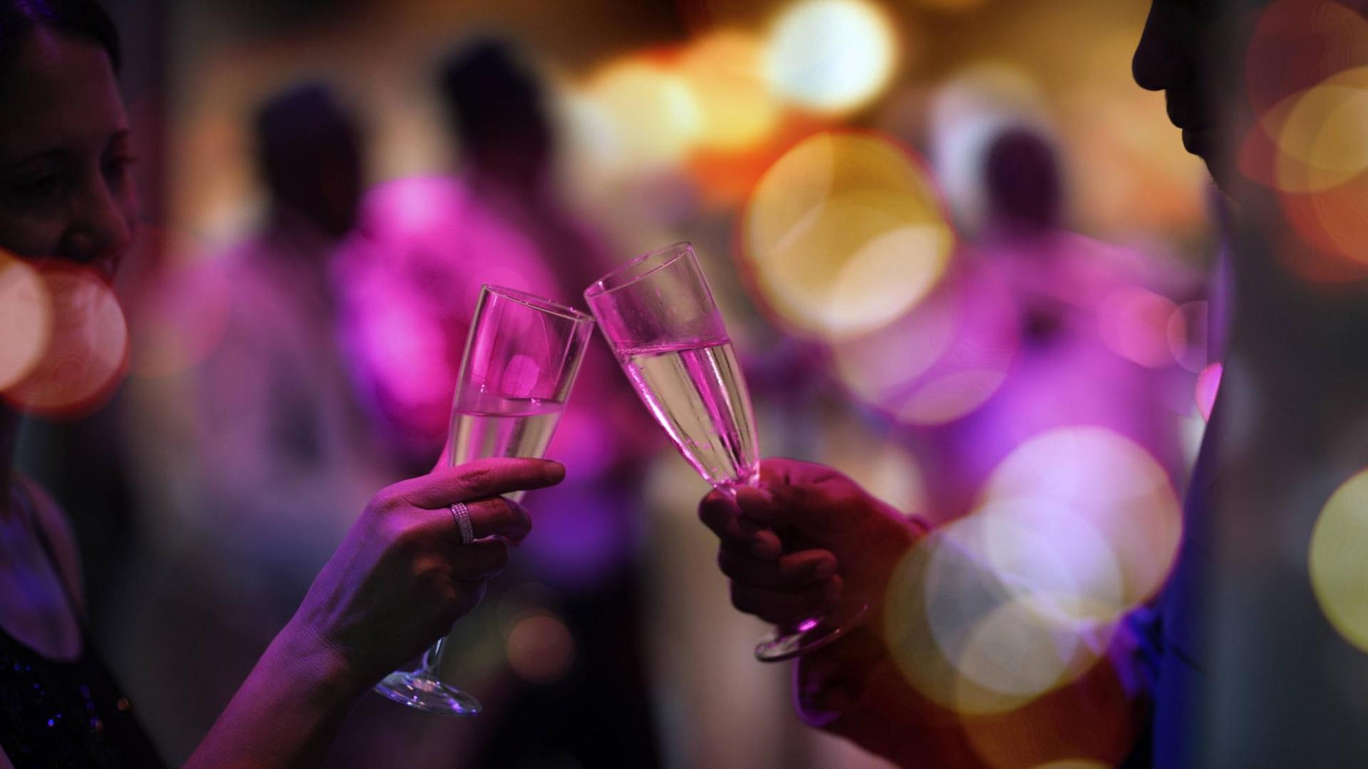 Menschen halten auf einer Party Gläser mit Alkohol darin. Menschen halten auf einer Party Gläser mit Alkohol darin.