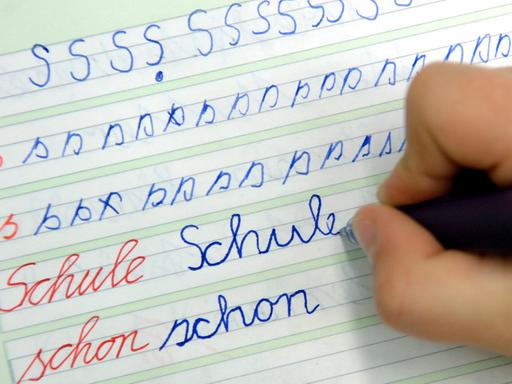 In der Dorfschule in Görzig nahe Beeskow schreibt ein Mädchen im Unterricht das Wort "Schule" in ihr Heft.