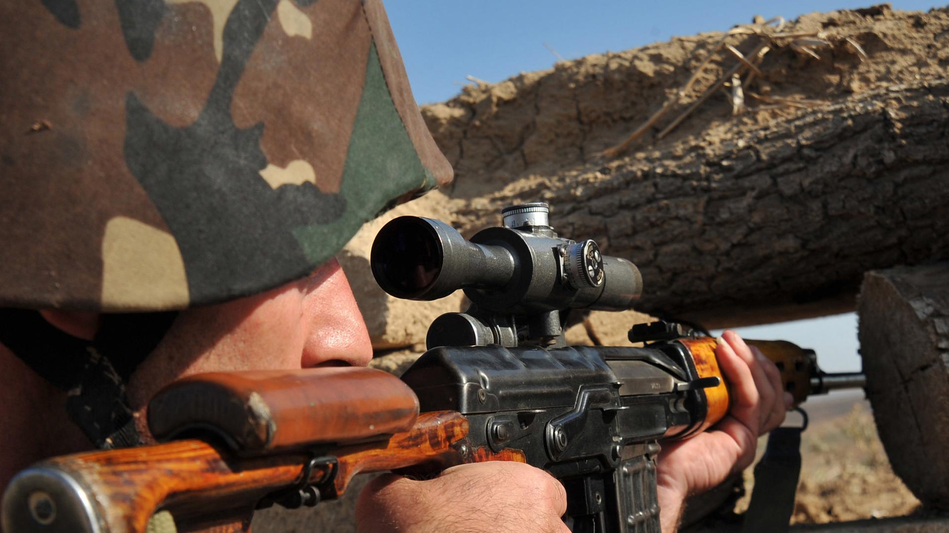 Ein armenischer Scharfschütze der selbsterklärten Republik Nagorny-Karabach richtet am 25.10.2012 seine Waffe auf die Frontlinie zu Aserbaidschan. An der seit 1994 bestehenden Waffenstillstandslinie sterben jährlich im Schnitt 30 Menschen durch Scharfschü Ein armenischer Scharfschütze der selbsterklärten Republik Nagorny-Karabach richtet am 25.10.2012 seine Waffe auf die Frontlinie zu Aserbaidschan. An der seit 1994 bestehenden Waffenstillstandslinie sterben jährlich im Schnitt 30 Menschen durch Scharfschü