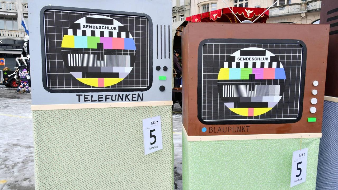 Nachgebaute TV-Geräte aus Sperrholz zeigen das Testbild des Sendeschlusses und Kalenderblätter mit dem 4. und 5. März, dem Datum der No-Billag-Abstimmung und des Tags danach.