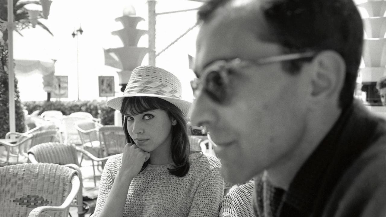 Der französiche Regisseur Jean-Luc Godard im Vordergrund mit Anna Karina. Der französiche Regisseur Jean-Luc Godard im Vordergrund mit Anna Karina.