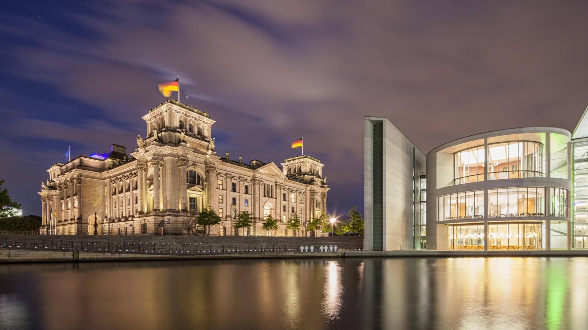 Sie sehen den Reichstag und das Paul-Löbe-Haus bei Nacht.