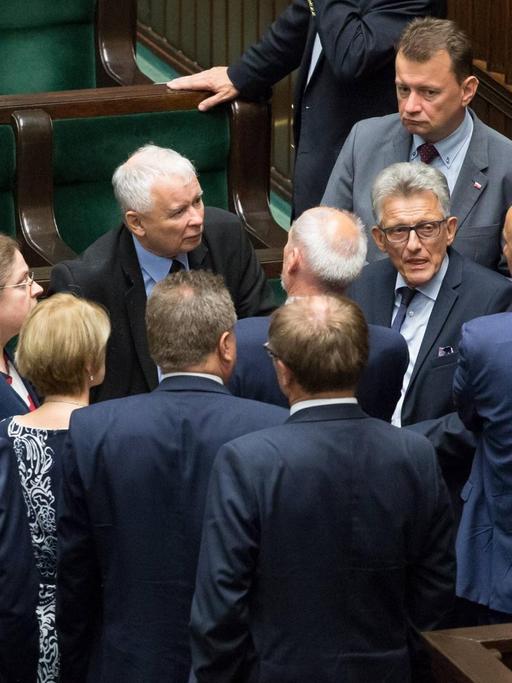 Jaroslaw Kaczynski, Chef der polnischen Regierungspartei PiS, während einer nächtlichen Debatte zur Justizreform im polnischen Parlament (Sejm), umringt von diskutierenden Abgeordneten.