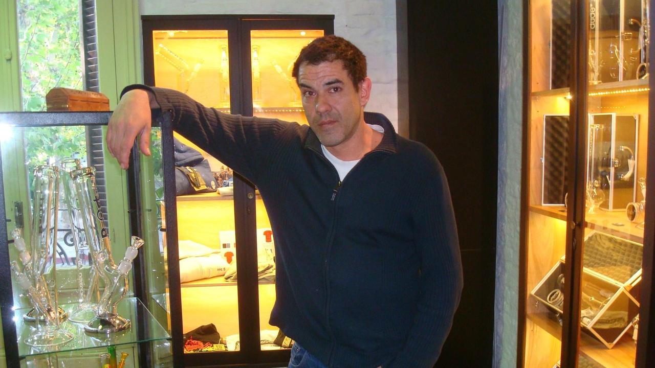 Juan Vaz, Anfang vierzig, mit Rauchutensilien in Vitrine Juan Vaz, Anfang vierzig, mit Rauchutensilien in Vitrine