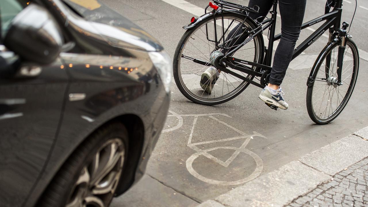 Eine Radfahrerin umfährt in Berlin ein auf dem Radweg stehendes Auto. Eine Radfahrerin umfährt in Berlin ein auf dem Radweg stehendes Auto.