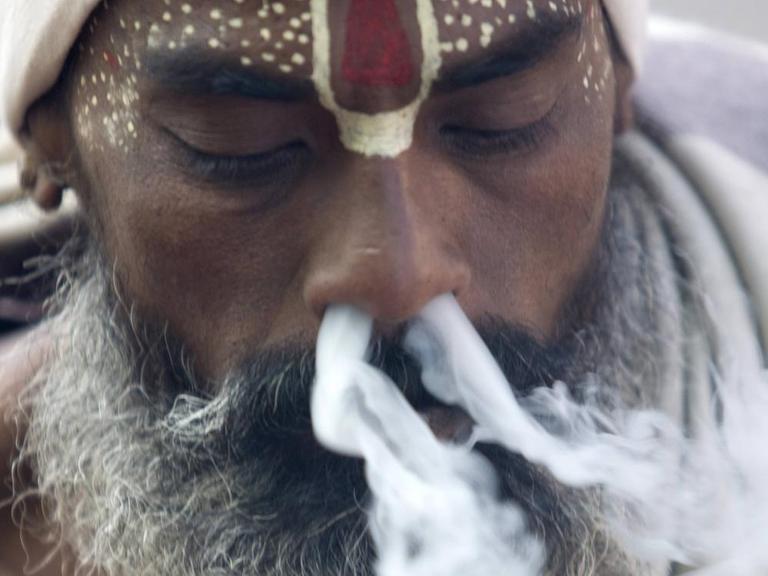 Einem Hindu Priester strömt Rauch aus beiden Nasenlöchern, Kathmandu, Nepal.