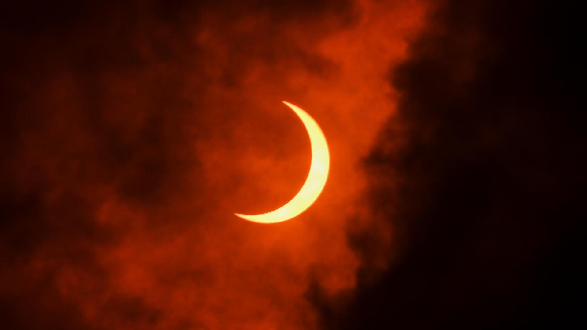Der dunkle Mond verdeckt einen großen Teil der hellen Sonne, eine Sichel aus strahlendem Licht bleibt zu sehen. Der dunkle Mond verdeckt einen großen Teil der hellen Sonne, eine Sichel aus strahlendem Licht bleibt zu sehen.