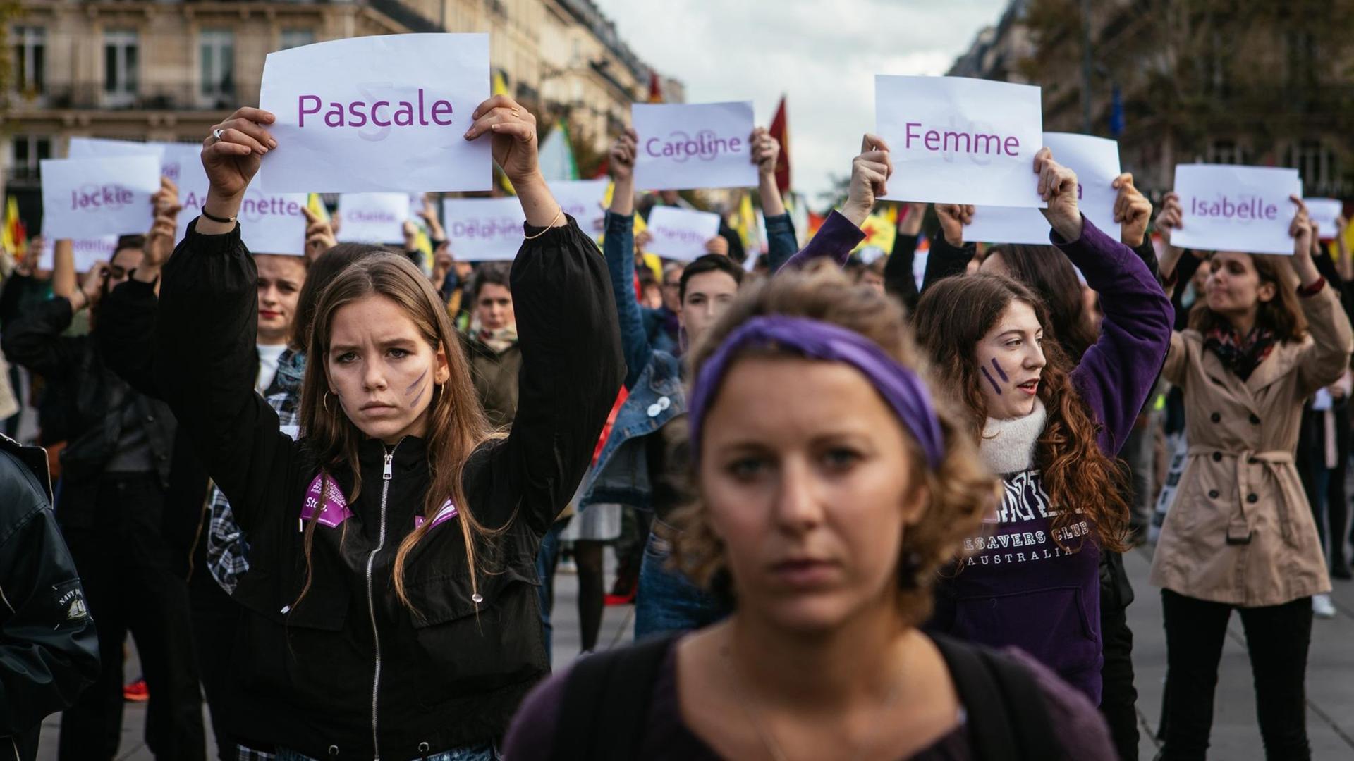 Demonstration gegen sexualisierte Gewalt und Femizide am 19. Oktober 2019 in Paris. Frauen halten Schilder hoch, auf denen die Namen von ermordeten Frauen stehen. Demonstration gegen sexualisierte Gewalt und Femizide am 19. Oktober 2019 in Paris. Frauen halten Schilder hoch, auf denen die Namen von ermordeten Frauen stehen.