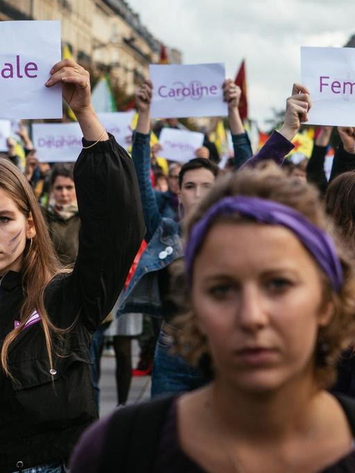 Demonstration gegen sexualisierte Gewalt und Femizide am 19. Oktober 2019 in Paris. Frauen halten Schilder hoch, auf denen die Namen von ermordeten Frauen stehen.
