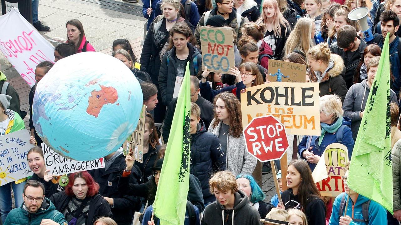 Schüler bei einer Demonstration halten Plakate mit Sprüchen wie "Kohle ins Museum" und "Stop RWE".