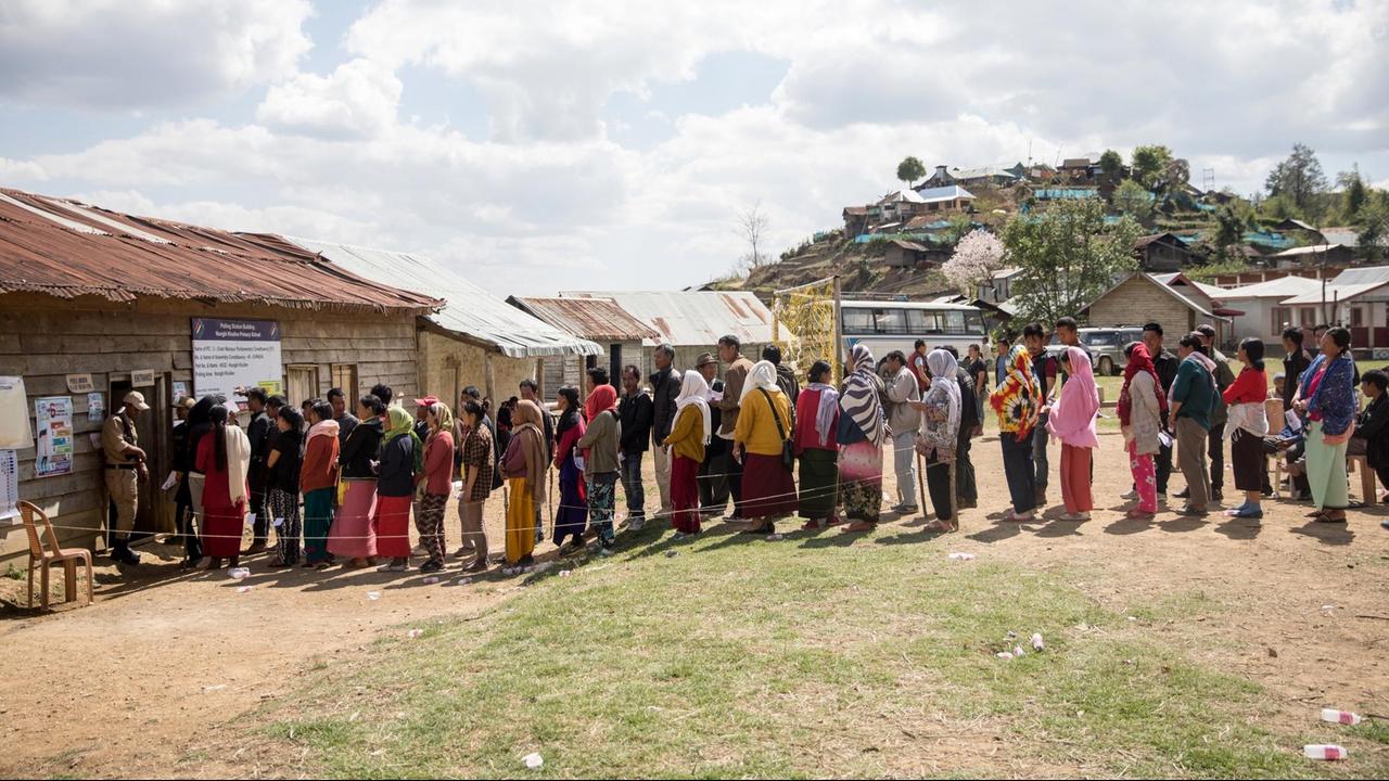 Menschen stehen vor einem Wahllokal im indischen Bundesstaat Manipur Schlange. Menschen stehen vor einem Wahllokal im indischen Bundesstaat Manipur Schlange.