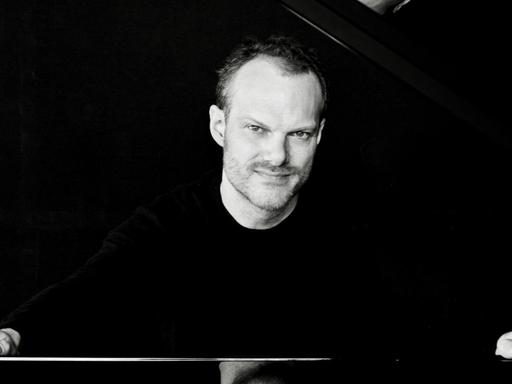 Der Pianist und Dirigent Lars Vogt sitzt an einem Flügel (Aufnahme aus 2016)