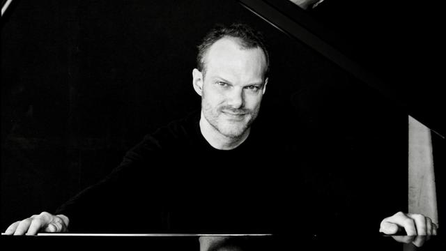 Der Pianist und Dirigent Lars Vogt sitzt an einem Flügel (Aufnahme aus 2016)