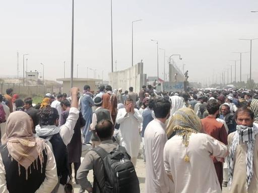 Zahlreiche Menschen warten vor dem Eingang des Flughafens von Kabul