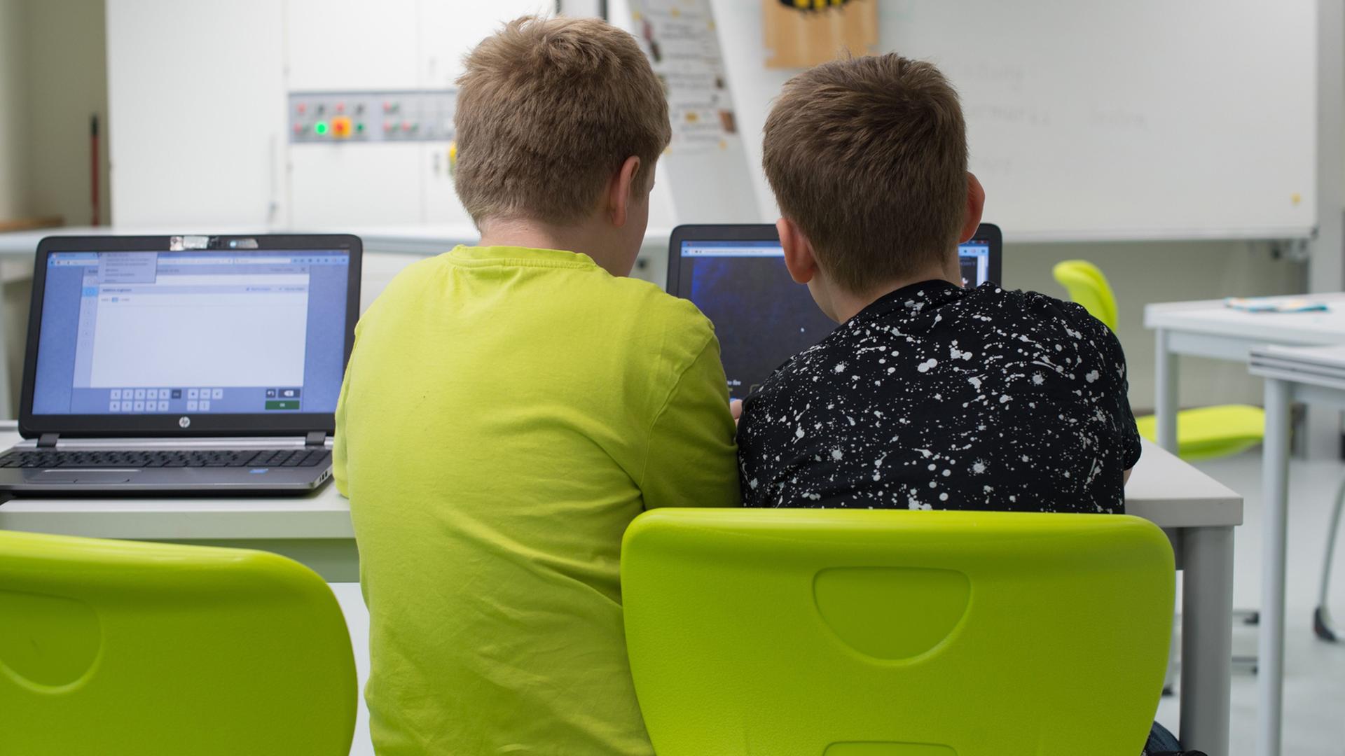 Zwei Schüler sitzen in einer Grundschule in Dresden an einem Laptop. Zwei Schüler sitzen in einer Grundschule in Dresden an einem Laptop.