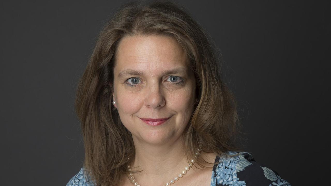 Eine Frau mit langen Haaren steht in einem Fotostudio und schaut in die Kamera Eine Frau mit langen Haaren steht in einem Fotostudio und schaut in die Kamera