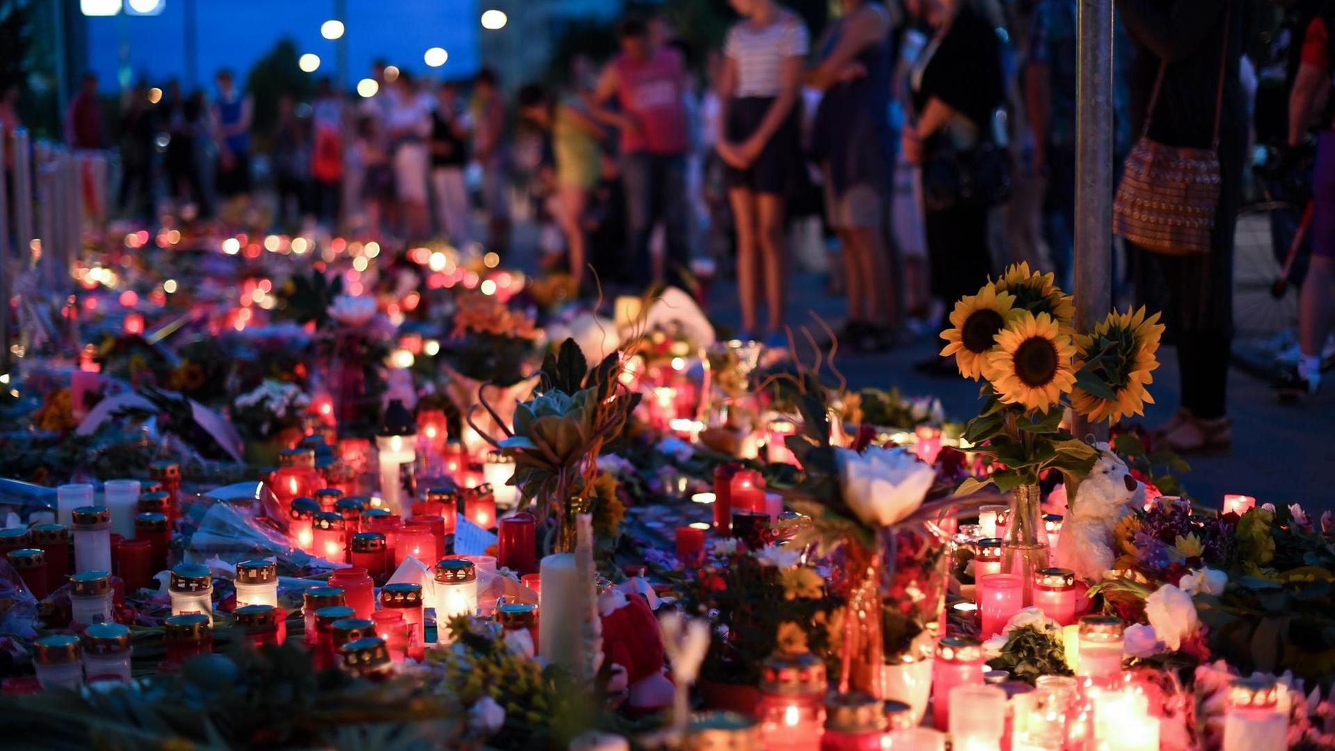 Blumen und Kerzen liegen am 24.07.2016 an der U-Bahn Station Olympia-Einkaufszentrums. Blumen und Kerzen liegen am 24.07.2016 an der U-Bahn Station Olympia-Einkaufszentrums.