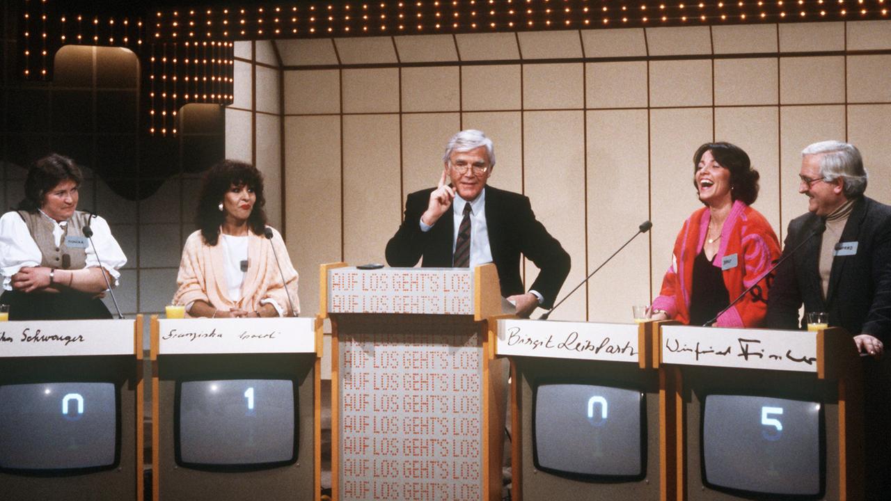 Joachim Fuchsberger mit Kandidaten in seiner Quizshow "Auf los geht's los" 1985 Joachim Fuchsberger mit Kandidaten in seiner Quizshow "Auf los geht's los" 1985