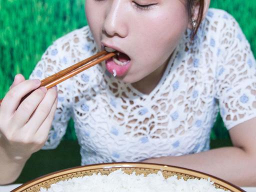 Eine junge Frau isst bei einem Wettbewerb in China Reis aus einer großen Schüssel.