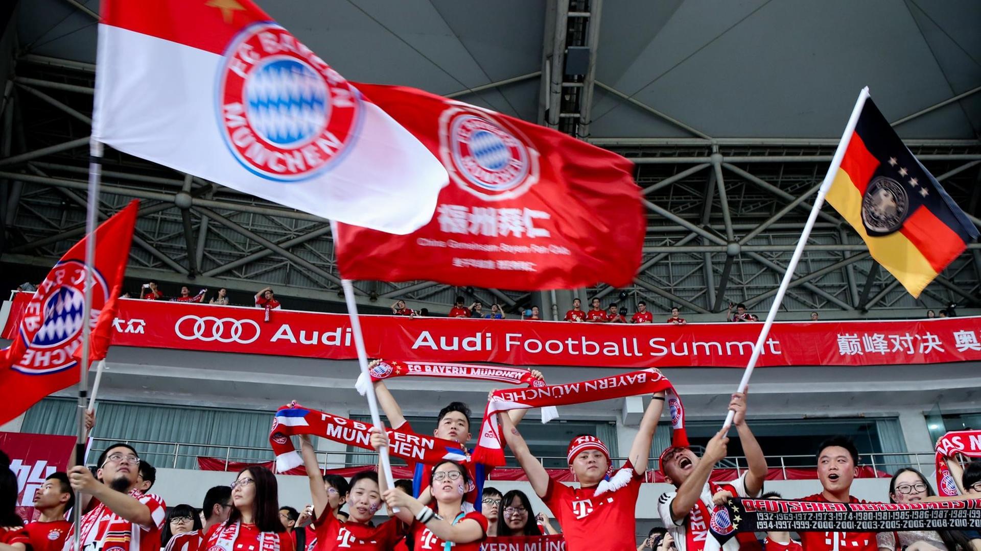 Chinesische Fans des FC Bayern München in Shanghai mit Bayern- und Deutschlandfahnen Chinesische Fans des FC Bayern München in Shanghai mit Bayern- und Deutschlandfahnen