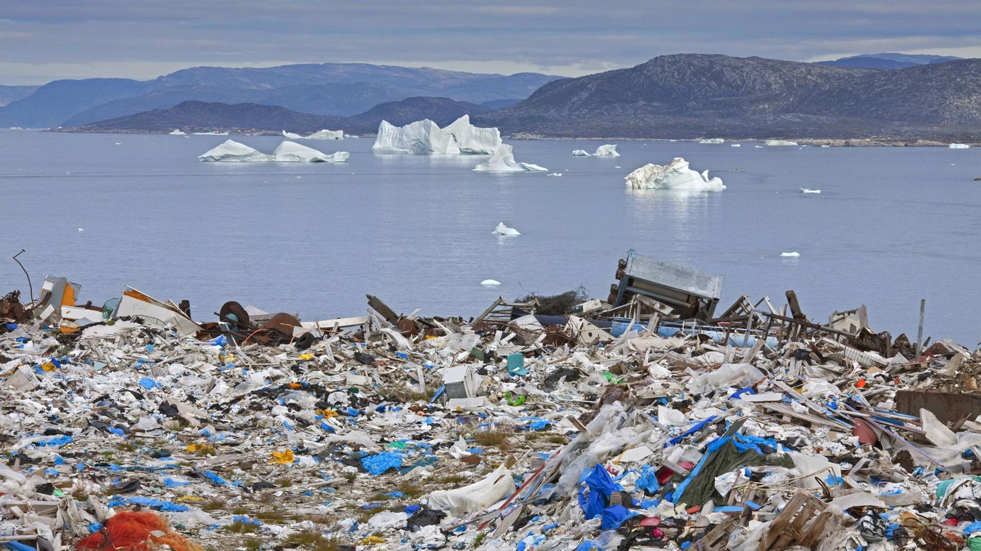 Eine Müllhalde am Ilulissat, Jakobshavn, Disko-Bay in Grönland befindet sich kurz vor dem Meer, auf dem kleine Eisberge fließen. Eine Müllhalde am Ilulissat, Jakobshavn, Disko-Bay in Grönland befindet sich kurz vor dem Meer, auf dem kleine Eisberge fließen.