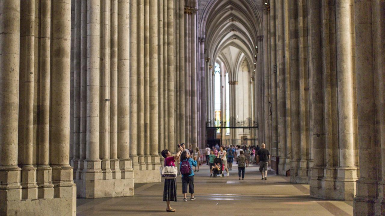 Touristen fotografieren im Kölner Dom.