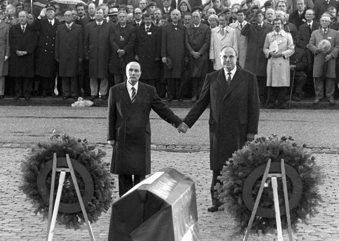  Historische Geste: Der französische Staatspräsident Francois Mitterrand (l) und Bundeskanzler Helmut Kohl reichen sich am 22.9.1984 über den Gräbern von Verdun die Hand. 