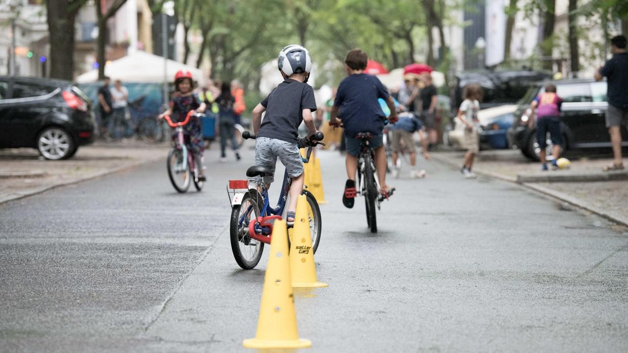 Kinder absolvieren auf der ersten temporären Spielstraße in Berlin einen Fahrradparcours. Kinder absolvieren auf der ersten temporären Spielstraße in Berlin einen Fahrradparcours.
