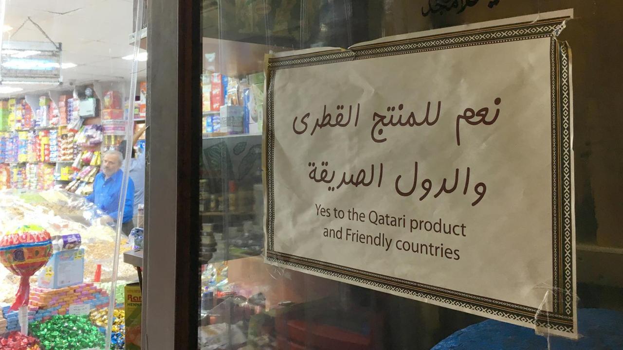 Auf dem Basar hängt ein Schild mit der Aufschrift: Schild: "Ja zu Produkten aus Katar – und ja zu befreundeten Ländern". Auf dem Basar hängt ein Schild mit der Aufschrift: Schild: "Ja zu Produkten aus Katar – und ja zu befreundeten Ländern".
