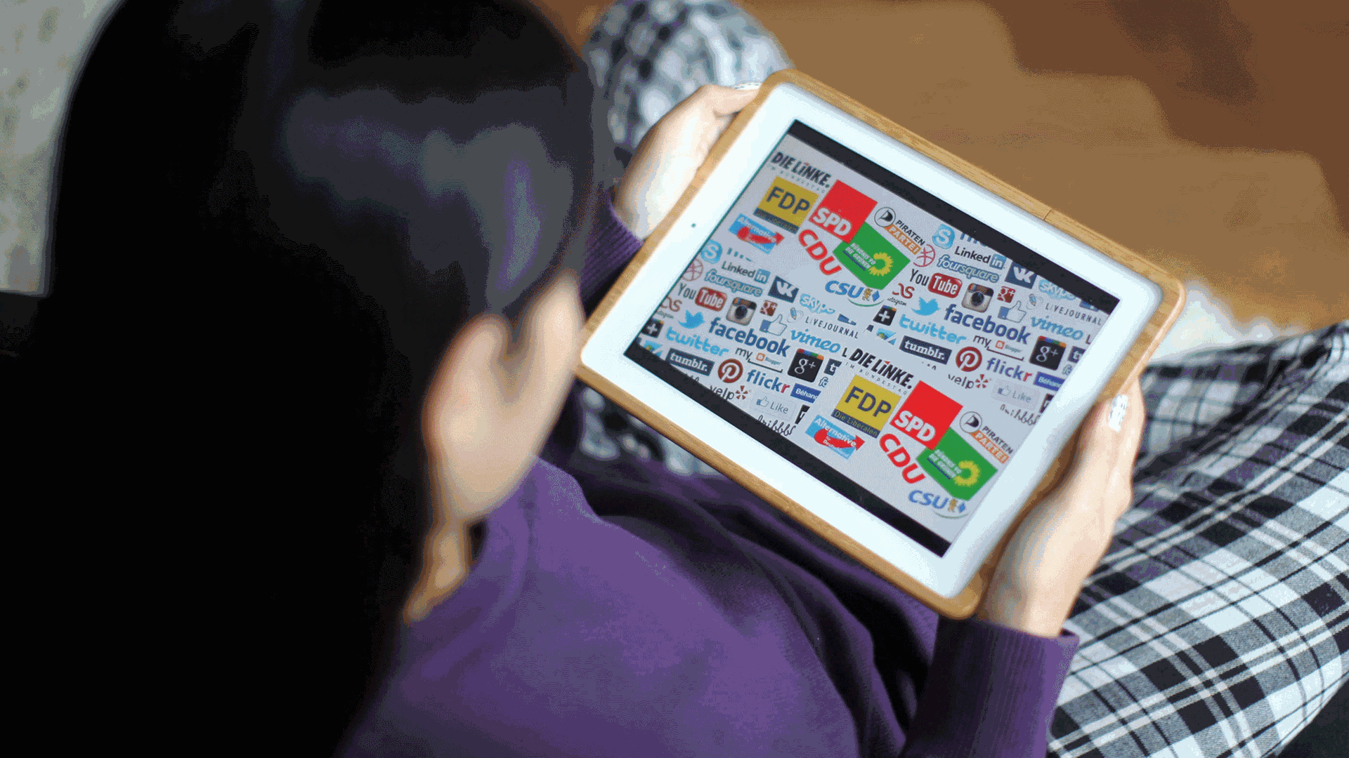 Eine Frau schaut sich Logos von verschiedenen deutschen Parteien und Social Media-Unternehmen auf ihrem Tablet-Computer an. Eine Frau schaut sich Logos von verschiedenen deutschen Parteien und Social Media-Unternehmen auf ihrem Tablet-Computer an.