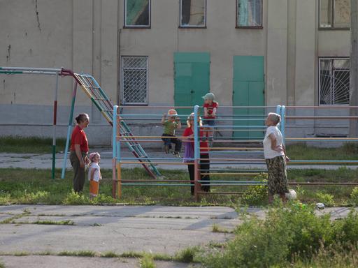 Kinder spielen auf einem Spielplatz in einer Plattenbausiedlung in Ribniza, Transnistrien.