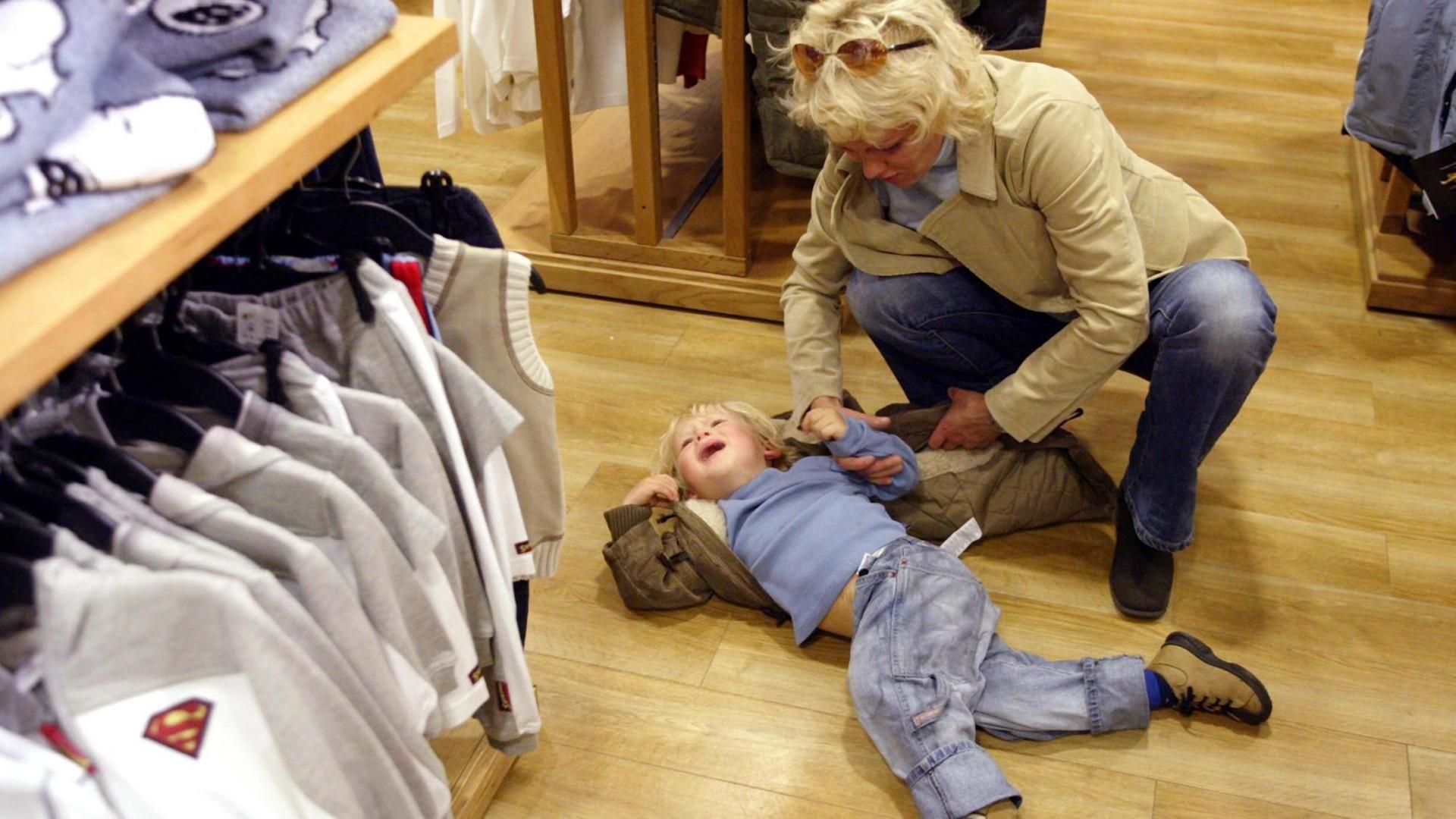 Nicht einfach für die Mutter: Ein kleines Kind hat sich mitten in einem Modegeschäft schreiend auf den Boden geworfen und will nicht mehr aufstehen. (Aufnahme vom 7.9.2003). | Nicht einfach für die Mutter: Ein kleines Kind hat sich mitten in einem Modegeschäft schreiend auf den Boden geworfen und will nicht mehr aufstehen. (Aufnahme vom 7.9.2003). |